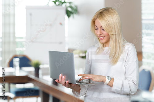 Smiling mature woman holding laptop