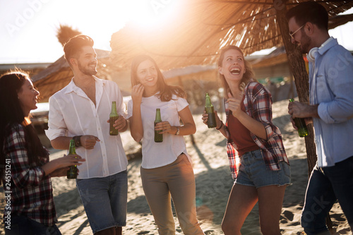 Group of young friends laughing and drinking beer