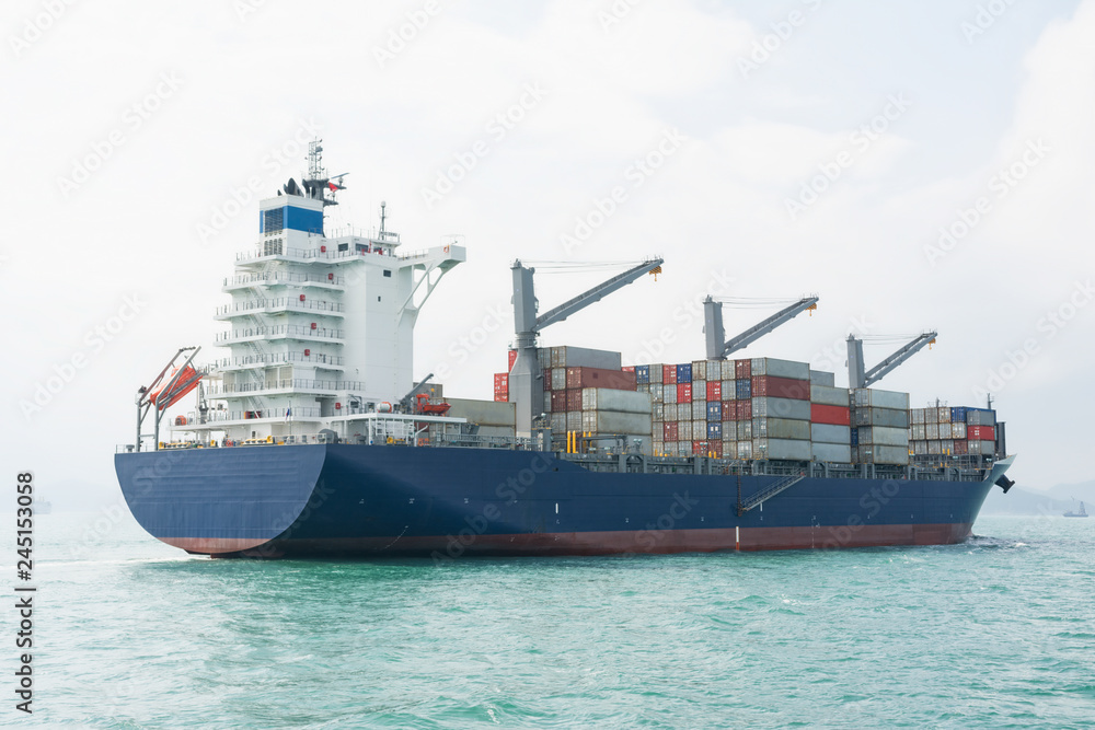 Fototapeta premium Container ship sailing calm waters in mid day