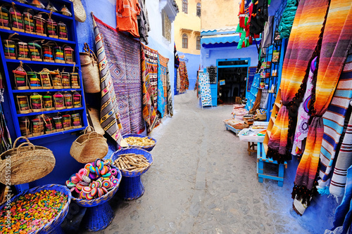 Moroccan handmade crafts, carpets and bags hanging in the narrow street of Essaouira in Morocco with selective focus