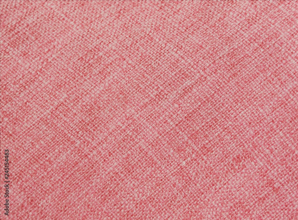Fototapeta premium coral color on fabric, with visible texture. close up of a trendy colored background with copy space. 