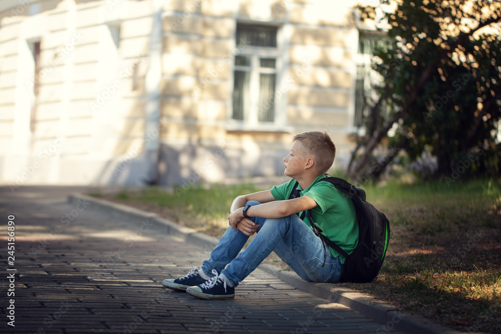 Obraz premium Sad alone boy sitting on road in the park outdoors.