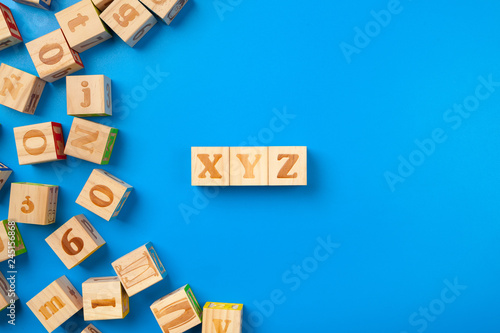 Wooden colorful alphabet blocks on blue background  flat lay  top view.