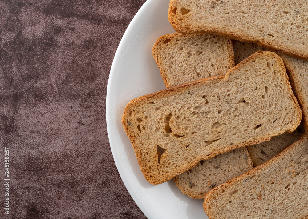 Rye melba toast slices on a white dish top close view Rye melba toast slices on a white dish top close view
