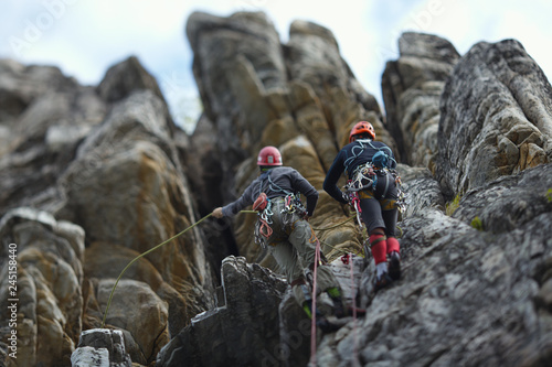  Two climbers are on a self-insurance on a complex rocky terrain. Two person rope. Tilt-Shift effect.