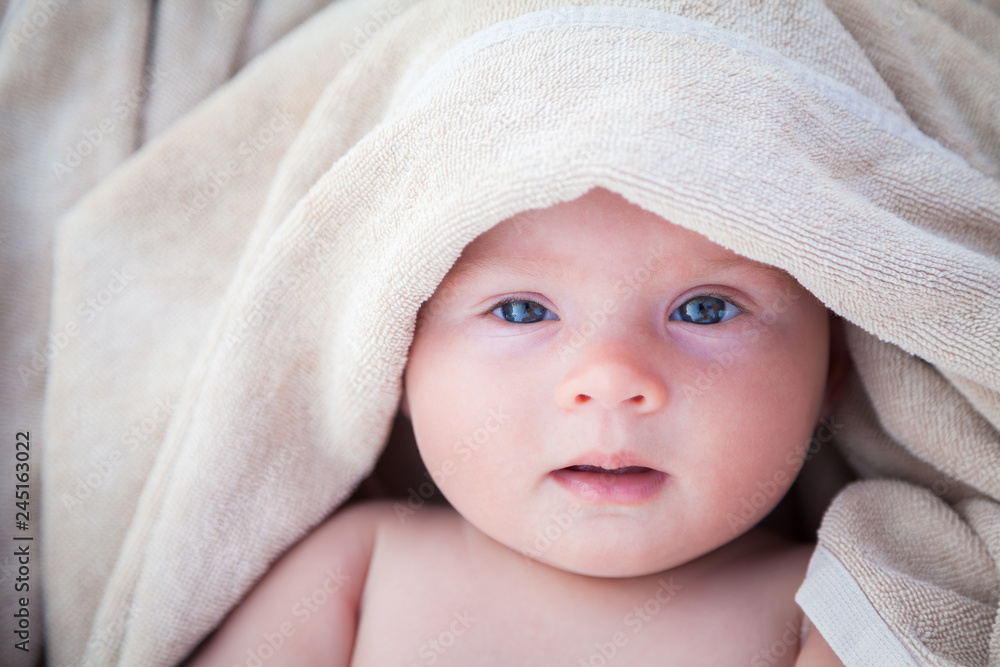baby girl covered with beige towel baby girl covered with beige towel