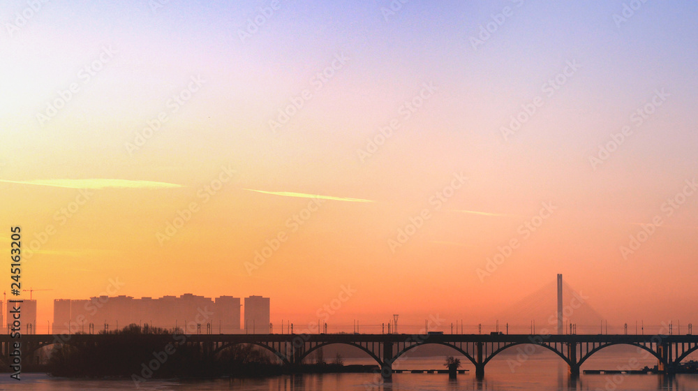 Sunset in the city. Silhouette of the bridge and buildings. Cityscape minimalism