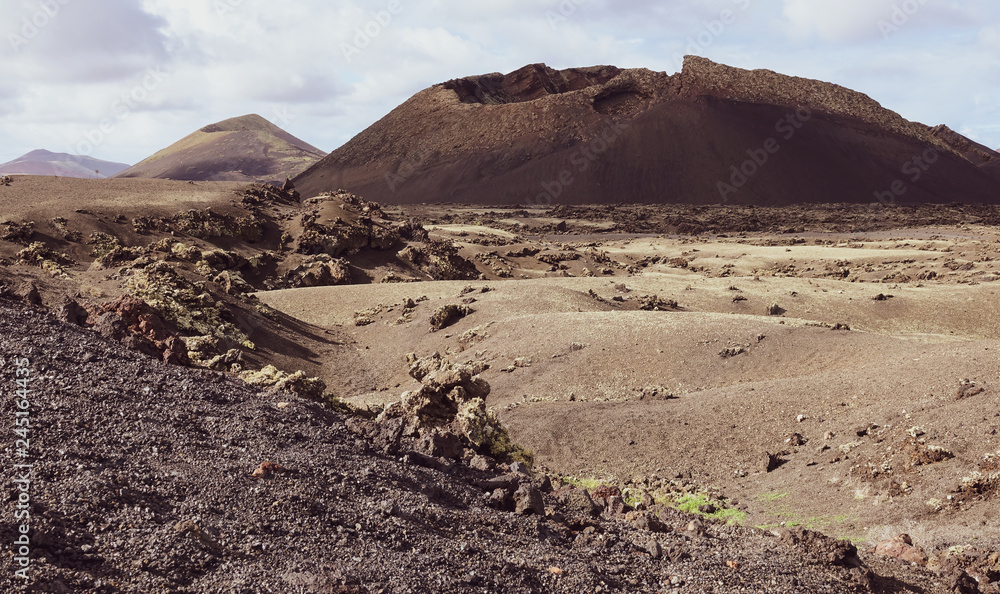 Volcano caldera crater with lava fields in the foreground. Lanzarote, Canary Islands.