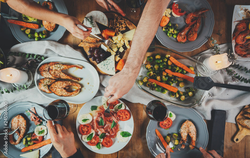 Top view shot of group of people enjoying healthy food and toasting at home, togetherness and friendship concept, filtered image, family dinner at home