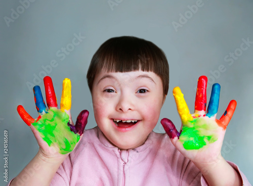 Cute little kid with painted hands. Isolated on grey background.