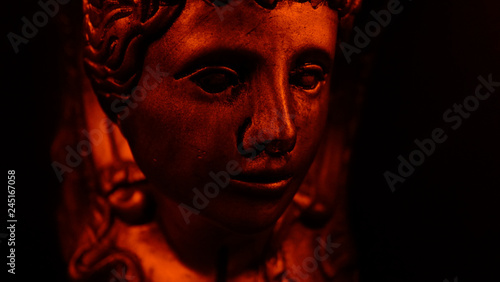 Antique face in red light