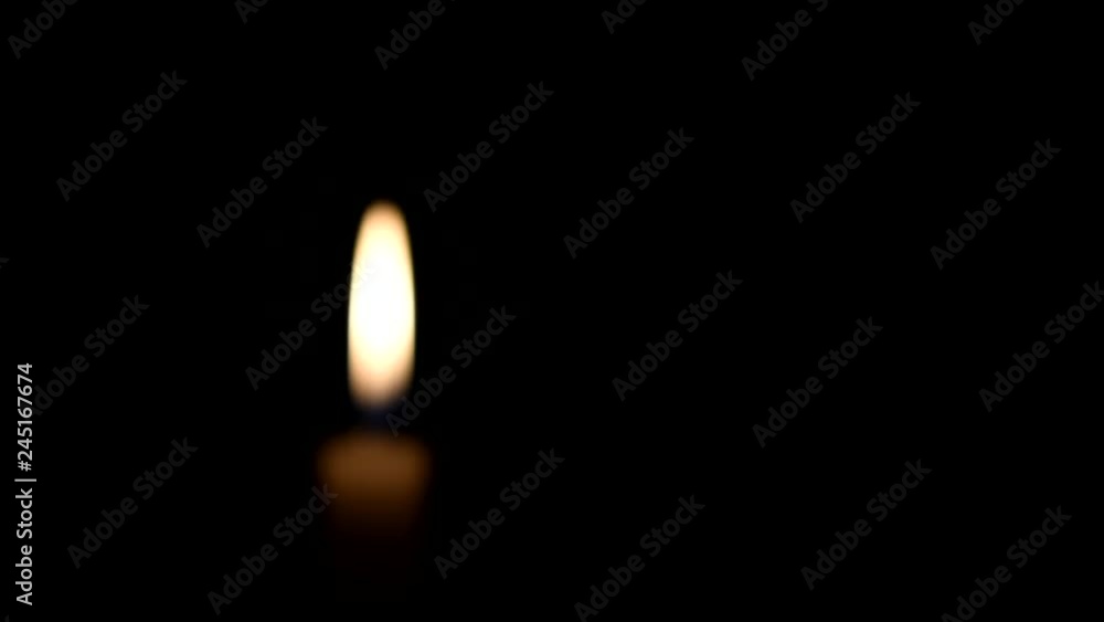 Blurred Candle flame on black background. Light candle burning. There`s room for your text. The concept of mourning, grief or sorrow. Located on the left side of the shot. Blurred Candle flame on black background. Light candle burning. There`s room for your text. The concept of mourning, grief or sorrow. Located on the left side of the shot.