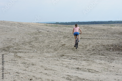 A woman riding a bike on a desert