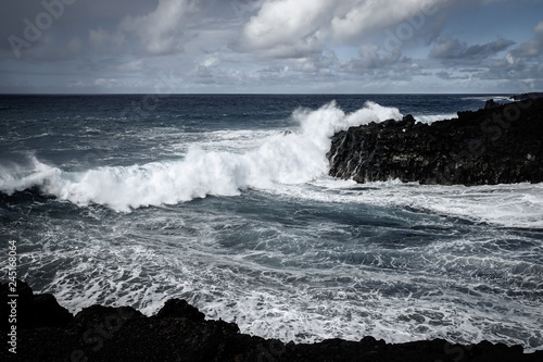 Waves crash along the black lava rock cliffs. Lanzarote, Canary Islands.