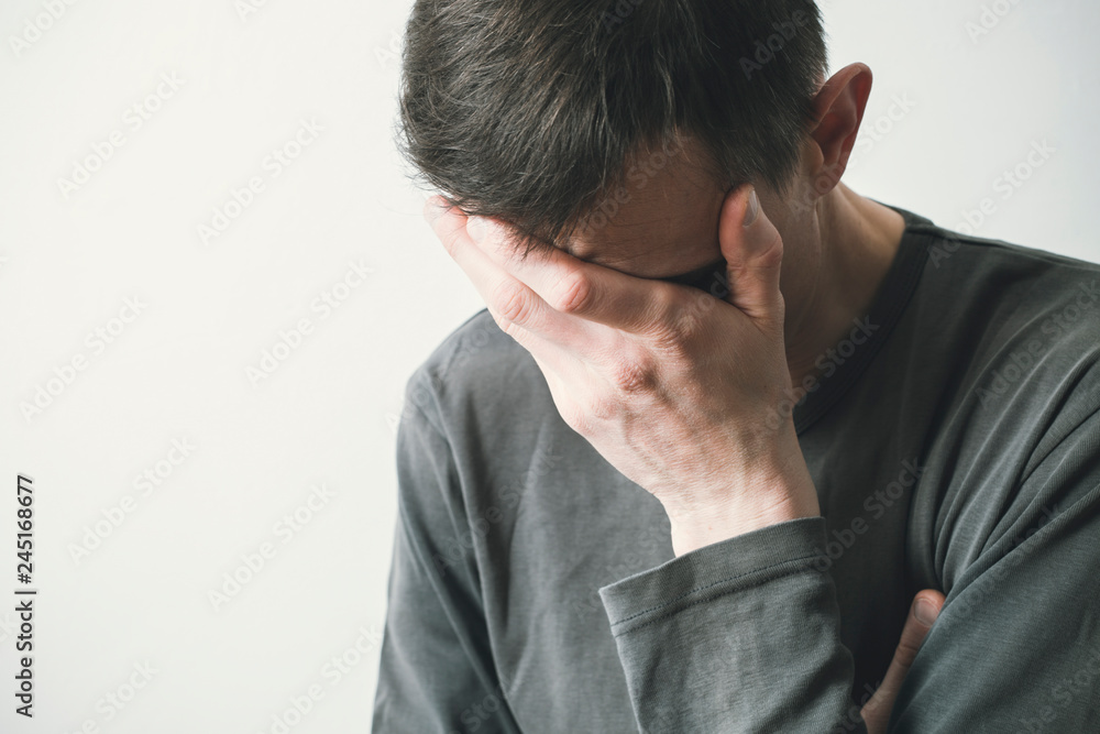 A sad man covers his face with his hands, he is crying. Depression is male. A sad man covers his face with his hands, he is crying. Depression is male.