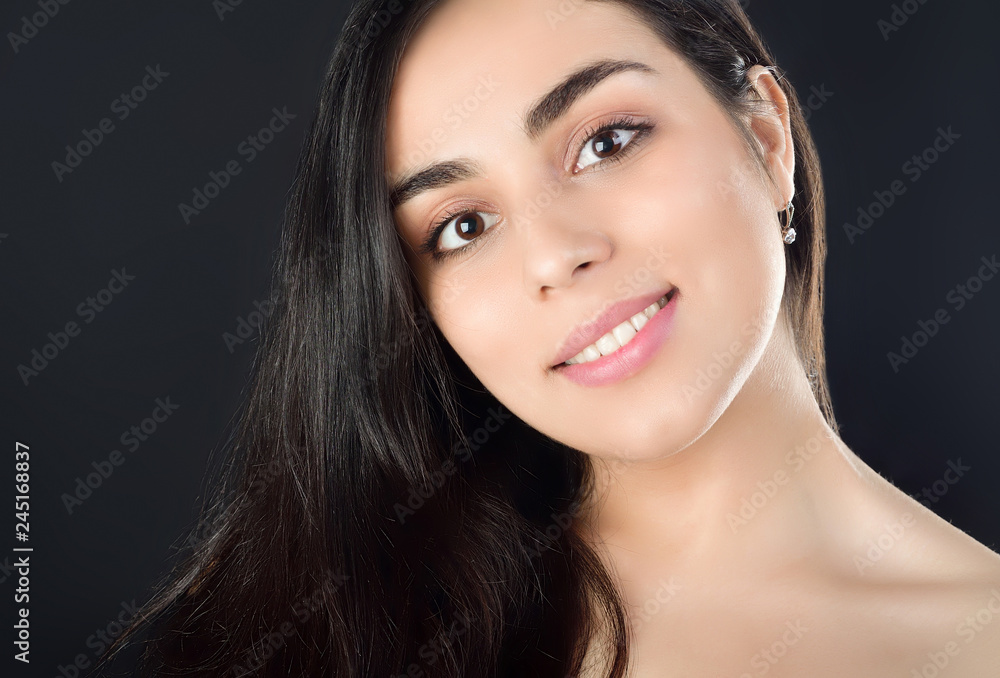 Portrait photo of a beautiful young brunette girl who smiles. Studio photography on black background Portrait photo of a beautiful young brunette girl who smiles. Studio photography on black background