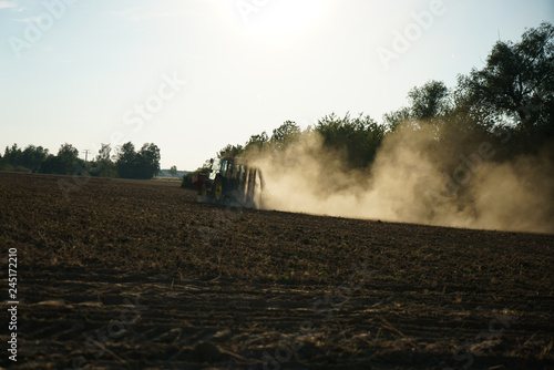 Just before sunset, a farmer was still working on a dusty field 