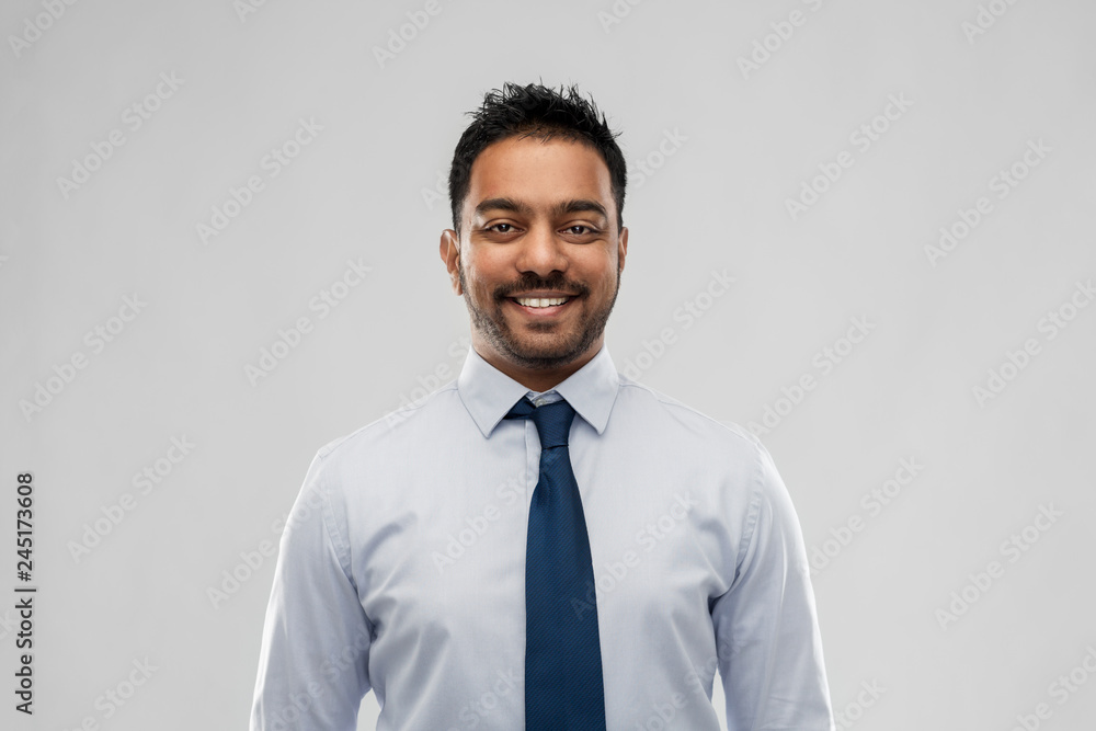 business, office worker and people concept - smiling indian businessman in shirt with tie over grey background business, office worker and people concept - smiling indian businessman in shirt with tie over grey background