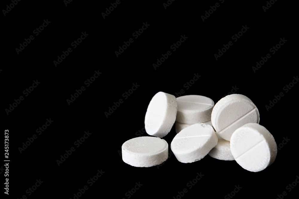 White medical pills on black background White medical pills on black background
