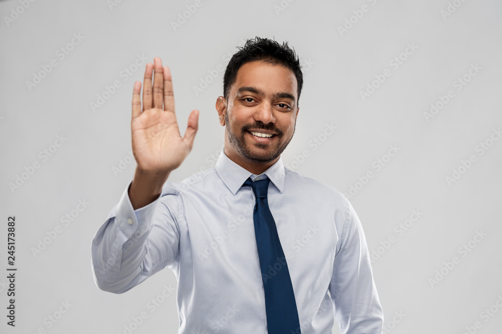 business, office worker and people concept - smiling indian businessman making high five gesture over grey background business, office worker and people concept - smiling indian businessman making high five gesture over grey background