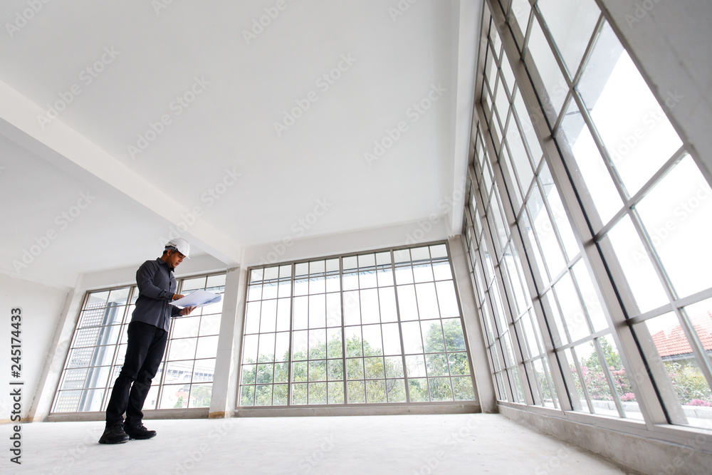 Fototapeta premium Engineer is checking the blue print and underconstruction room