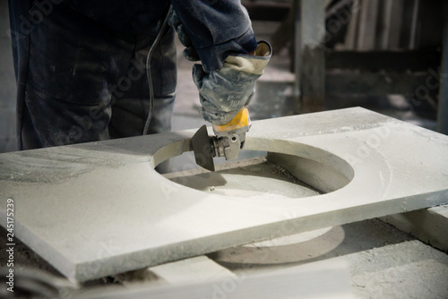 Man polishing marble stone table by small angle grinder