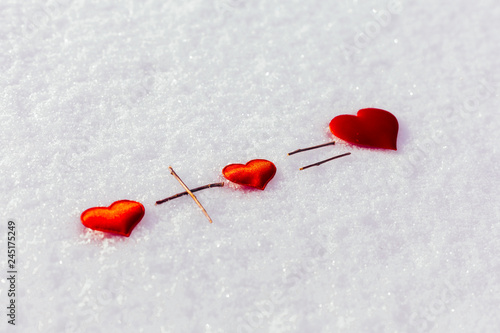 Two small red hearts and one big on the snow. Love. Background Valentines Day. Valentines day cards. © Smile