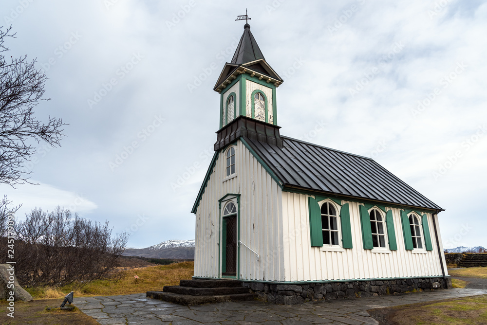 Historic White Wooden Chapel with Green Shutters in Iceland on a Cloudy Autumn Day