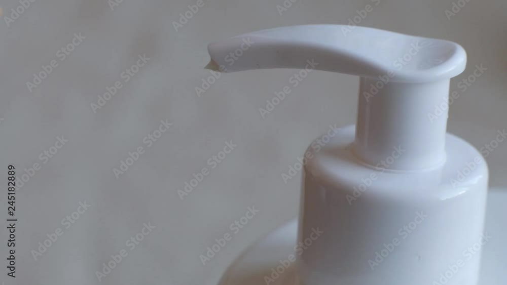 Finger push button on cream bottle in clean hand in bathroom. Skin care, hygiene and healthy life concept. Close up Finger push button on cream bottle in clean hand in bathroom. Skin care, hygiene and healthy life concept. Close up