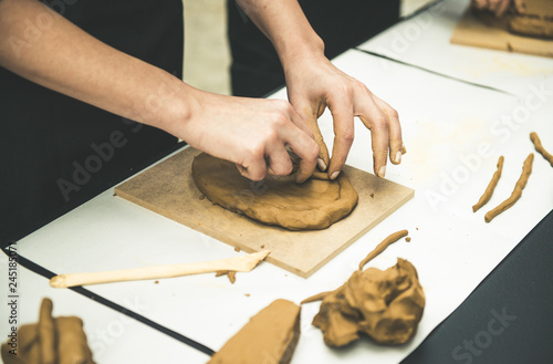 Female mask works with clay, craftsman hands close up