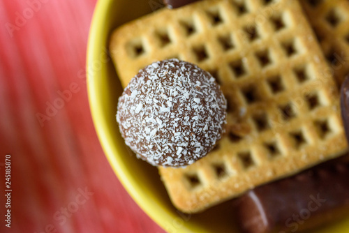 Yellow tareka with cookies and chocolates on a red wooden background. photo