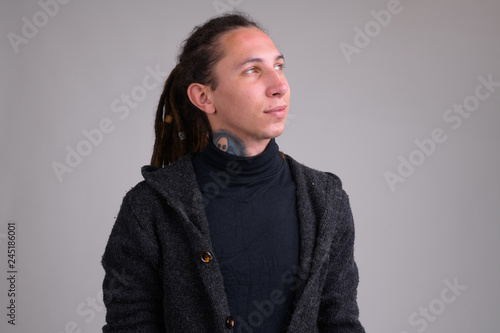 Portrait of young handsome man with dreadlocks thinking