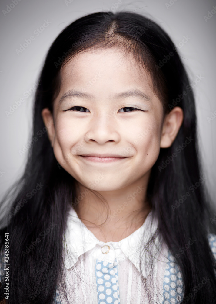 Close-up portrait of cute Asian Chinese little girl indoors against white background Close-up portrait of cute Asian Chinese little girl indoors against white background