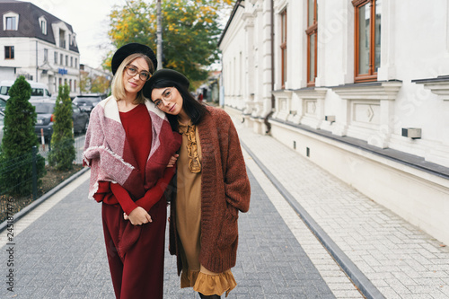 Women models in elegant autumn clothes and glasses over urban city background