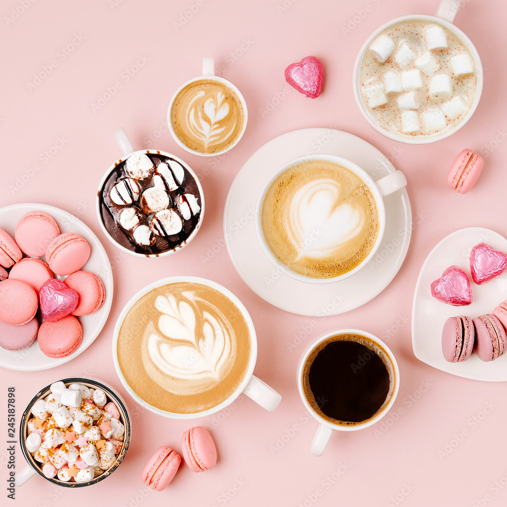 Various kinds of coffee in cups of different size with candys and macaroons on pale pink background.  Coffee  Time concept.  Flat lay, top view