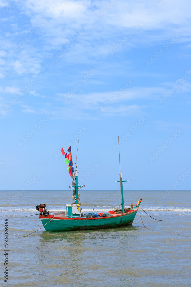 Traditional fishing boat tied with rope in sea near beach