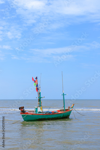 Traditional fishing boat tied with rope in sea near beach