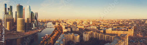 panorama high-rise buildings and transport of metropolis, traffic and blurry lights of cars on multi-lane highways and road junction at sunset in Moscow.