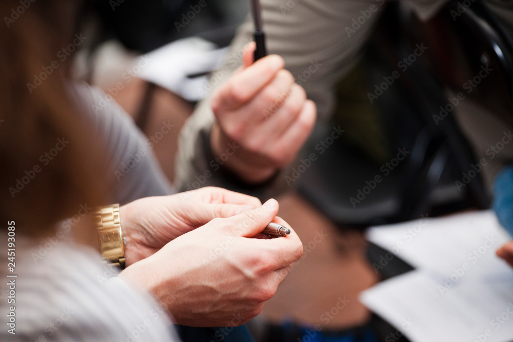 Two communicate in the office: the girl holds the pen in hand Two communicate in the office: the girl holds the pen in hand