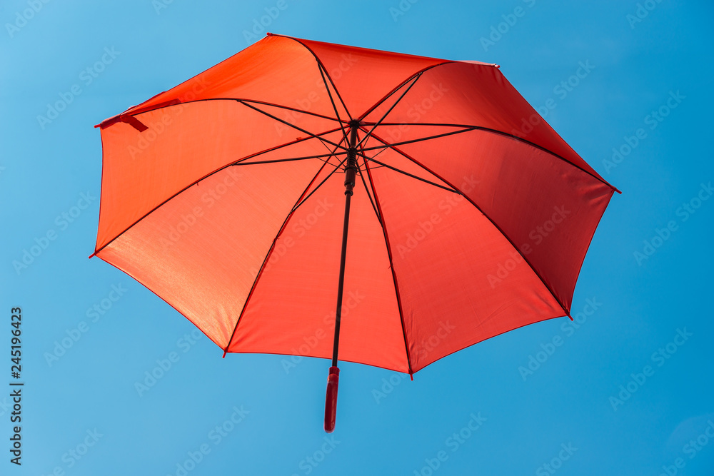 Roter Regenschirm im blauen Himmel