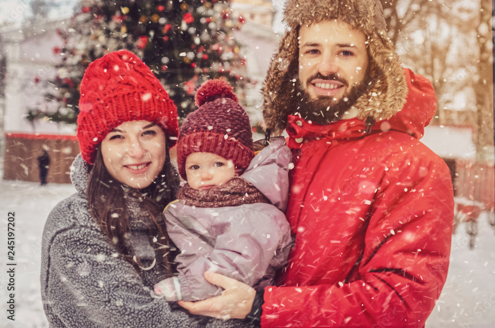 Cute family playing in the park in winter. Enjoying spending time together. Family concept.