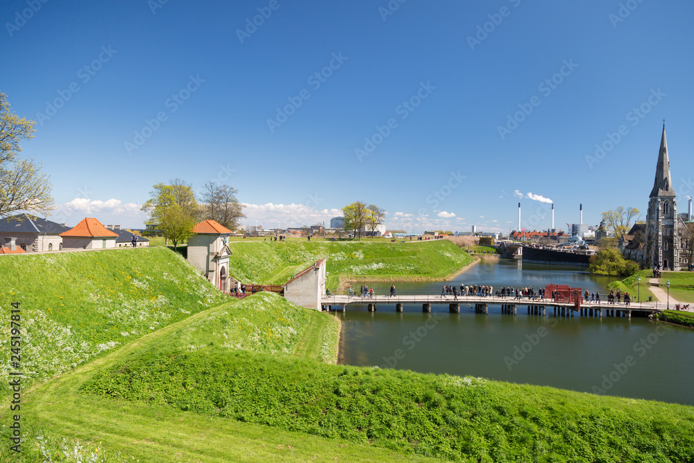 COPENHAGEN, DENMARK. View from the Kastellet fortress on the King's Gate, bridge, moat and St Alban's Church. Located near the harbour with the Little Mermaid statue.