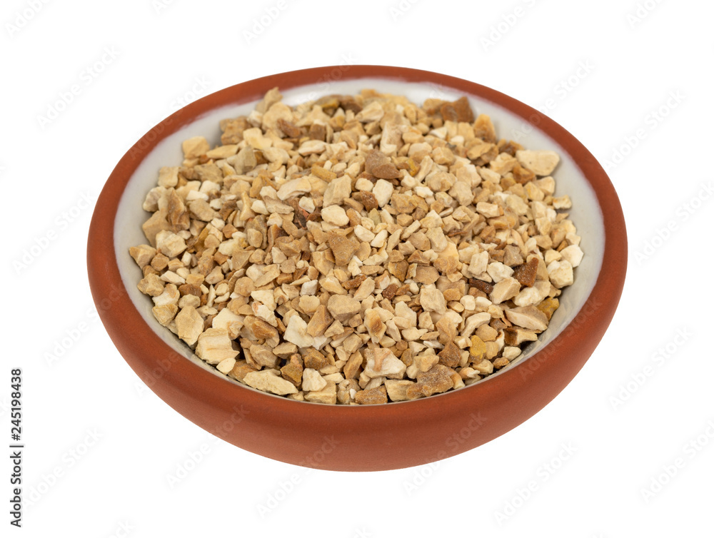 Cut orris root in a small bowl on a white background Cut orris root in a small bowl on a white background