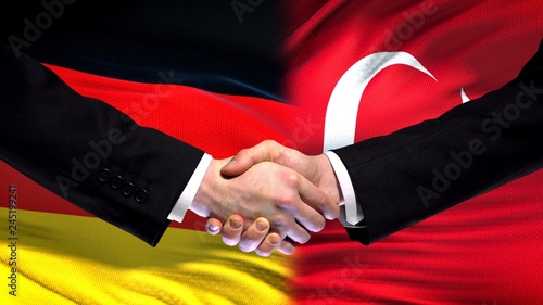 Germany and Turkey handshake, international friendship relations flag background