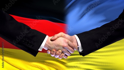 Germany and Ukraine handshake international friendship relations flag background