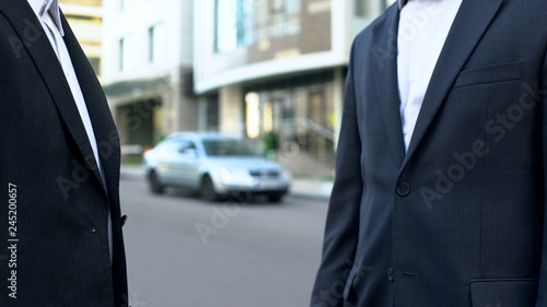 Wallpaper Mural Two businessmen talking outside office building, discussing financial deal Torontodigital.ca