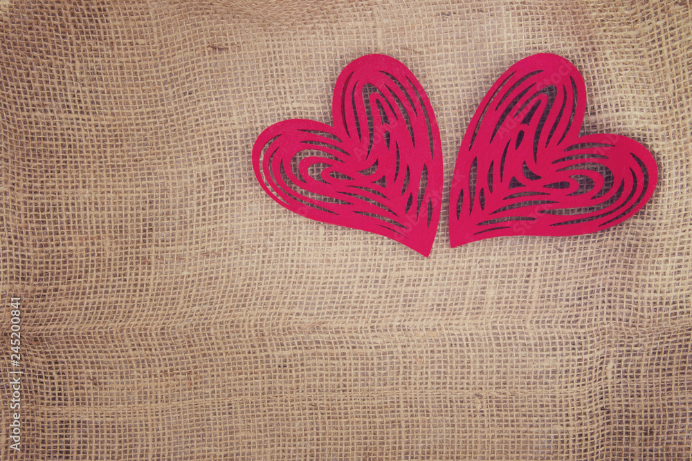 Two hearts side by side on the texture burlap.