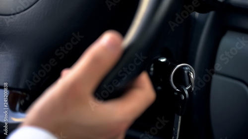 Man driving car  holding hand on wheel  close up on keys  transportation