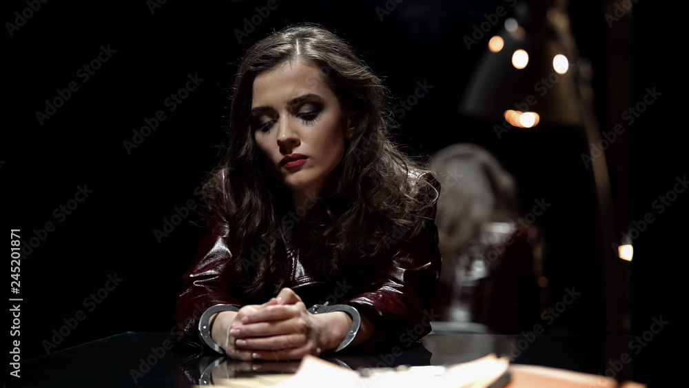 Impudent woman in handcuffs waiting for detective in interrogation room, arrest Impudent woman in handcuffs waiting for detective in interrogation room, arrest