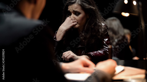 Photographie Female criminal crying regretfully, giving open-hearted confession about crime